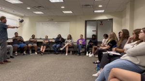 Students sitting in desks in during a classroom session with Jeremy Myers.